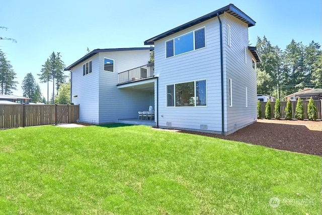 rear view of property featuring a balcony, a yard, and a patio area