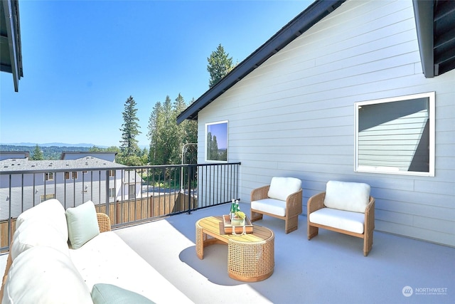 view of patio featuring a balcony, a mountain view, and an outdoor hangout area