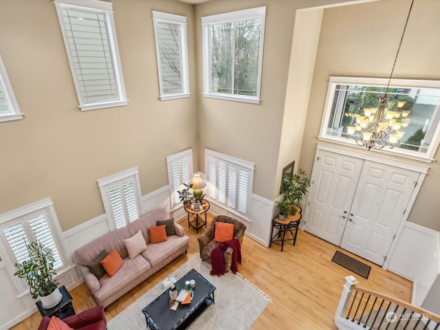 living room with plenty of natural light, a notable chandelier, and hardwood / wood-style flooring