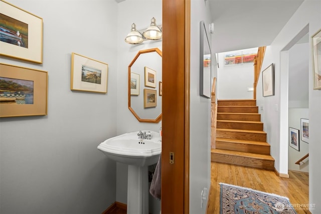 bathroom featuring a sink, baseboards, and wood finished floors