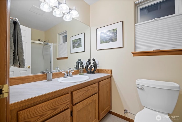 bathroom with toilet, vanity, and a shower with shower door