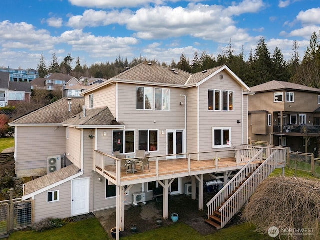 back of house featuring a deck, stairs, fence, and roof with shingles