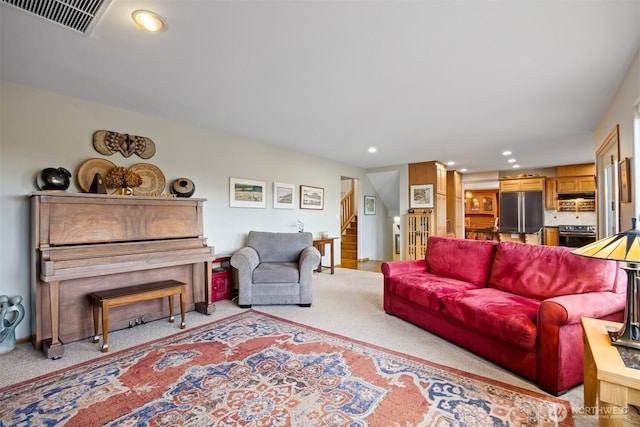 carpeted living room featuring recessed lighting, visible vents, and stairway