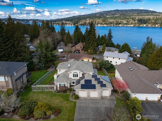 drone / aerial view with a residential view, a forest view, and a water view