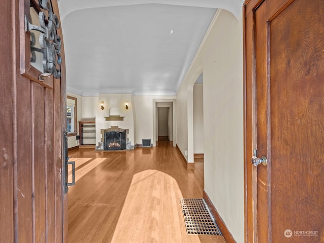 unfurnished living room featuring ornamental molding and light hardwood / wood-style floors