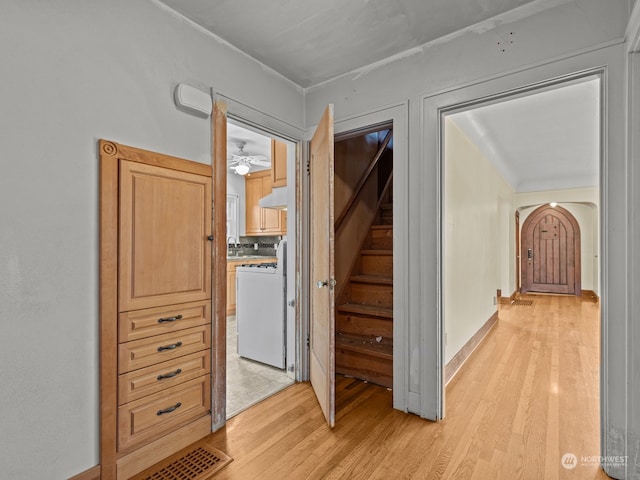 corridor with washer / dryer and light wood-type flooring