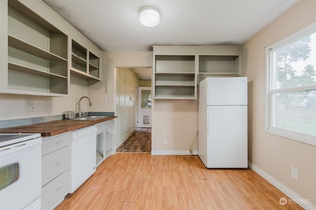 kitchen with wooden counters, white appliances, light hardwood / wood-style floors, and sink