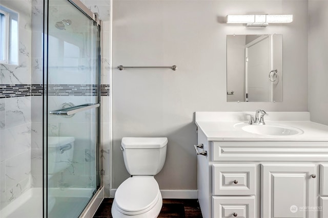 bathroom with vanity, a shower with shower door, and toilet