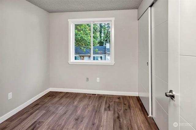 unfurnished bedroom with hardwood / wood-style flooring and a textured ceiling