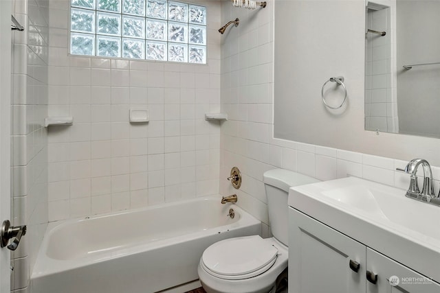 full bathroom featuring tile walls, vanity, toilet, and tiled shower / bath