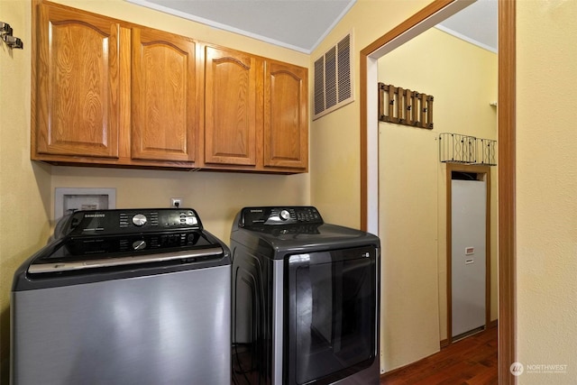 washroom with ornamental molding, cabinets, dark hardwood / wood-style floors, and independent washer and dryer