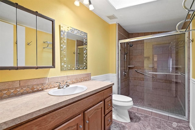 bathroom featuring vanity, toilet, and an enclosed shower