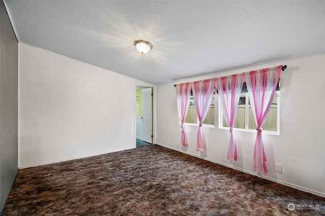 carpeted spare room with a textured ceiling