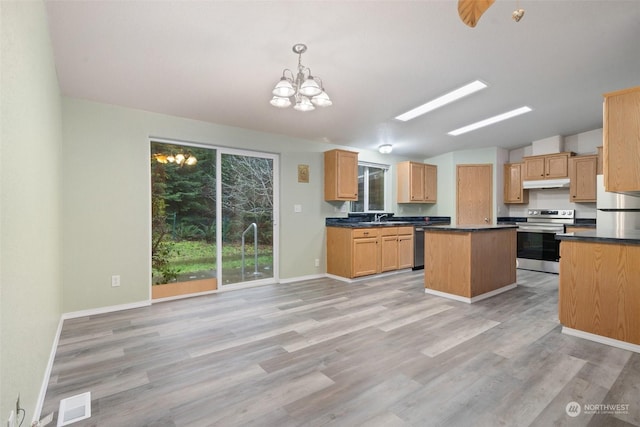 kitchen with decorative light fixtures, a center island, vaulted ceiling, stainless steel appliances, and light hardwood / wood-style floors