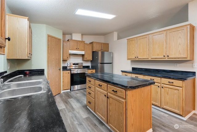 kitchen featuring sink, a center island, a textured ceiling, light wood-type flooring, and stainless steel appliances