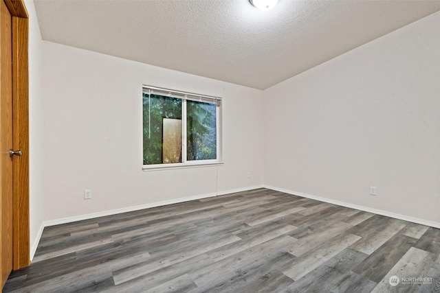 empty room featuring dark wood-type flooring and a textured ceiling