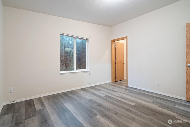 spare room featuring wood-type flooring and a textured ceiling