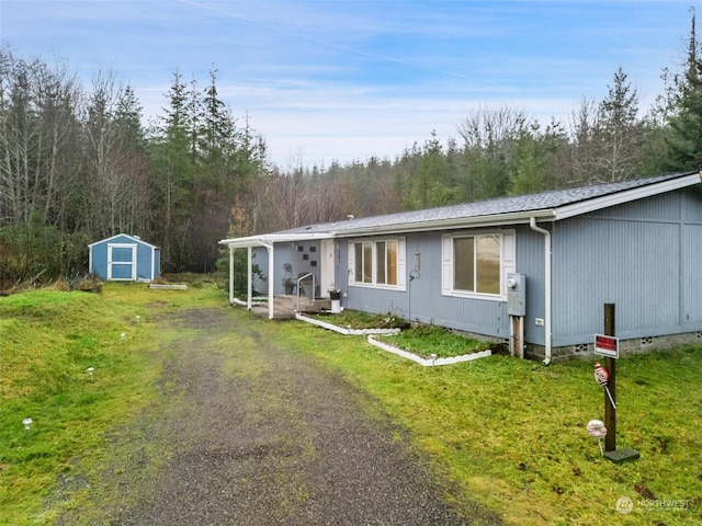 view of front of property with a shed and a front lawn