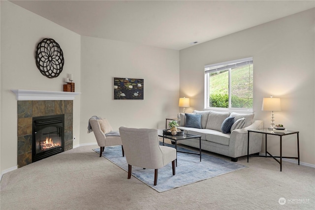 living room featuring a tiled fireplace and carpet flooring