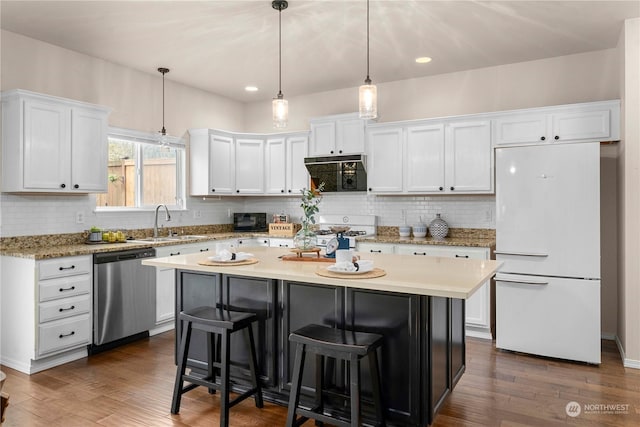 kitchen with white appliances, a center island, pendant lighting, dark wood-type flooring, and white cabinets