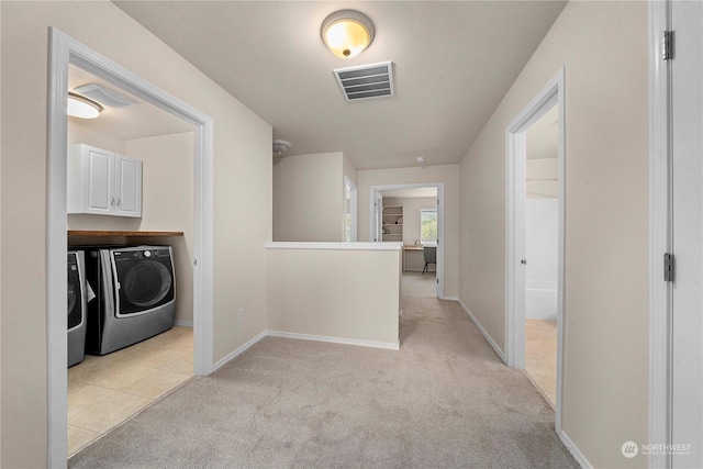 hallway with washer and dryer and light carpet