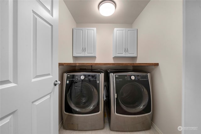 clothes washing area with washer and dryer and light tile patterned floors