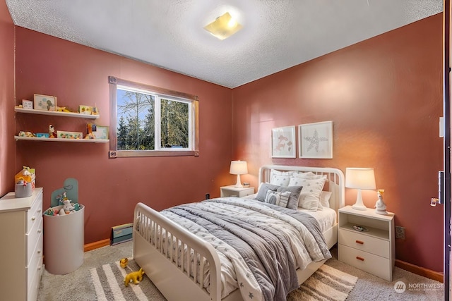 carpeted bedroom with a baseboard radiator and a textured ceiling