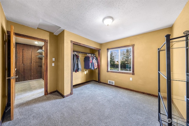 unfurnished bedroom featuring carpet, a textured ceiling, and a closet