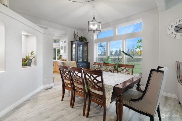 dining space featuring plenty of natural light, a chandelier, and light wood-type flooring