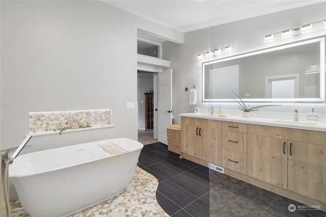 bathroom with tile patterned floors, vanity, and a tub