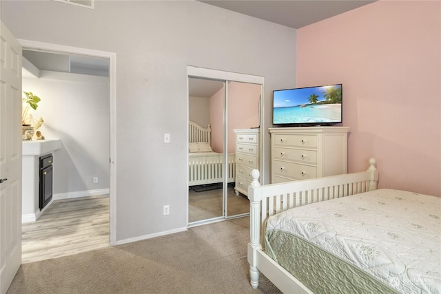 bedroom featuring light carpet and a closet