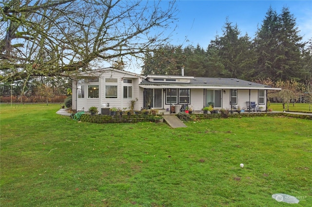 back of house with a lawn and central AC