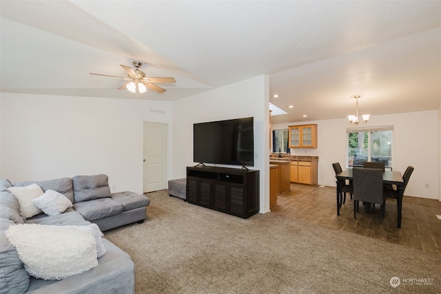 living room featuring ceiling fan with notable chandelier, hardwood / wood-style flooring, and lofted ceiling