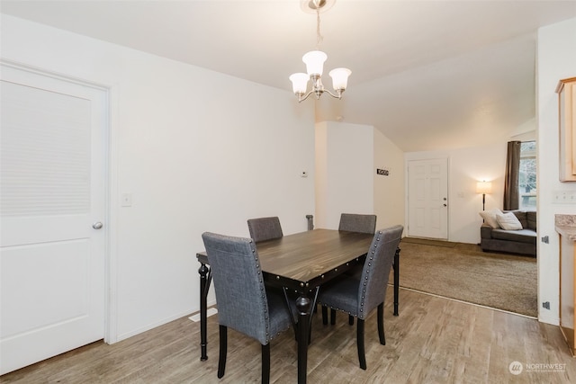 dining area with light hardwood / wood-style flooring and a chandelier