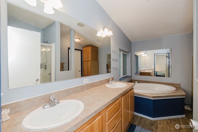 bathroom with plus walk in shower, an inviting chandelier, vaulted ceiling, vanity, and hardwood / wood-style flooring