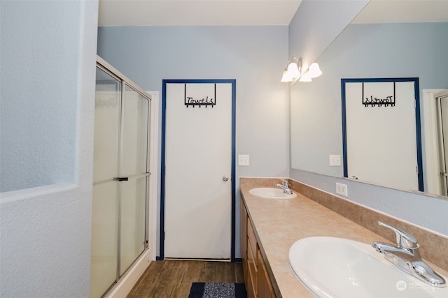 bathroom with a shower with door, vanity, and wood-type flooring