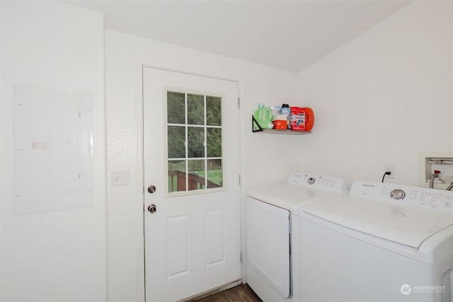 laundry room with dark hardwood / wood-style flooring, electric panel, and washing machine and clothes dryer