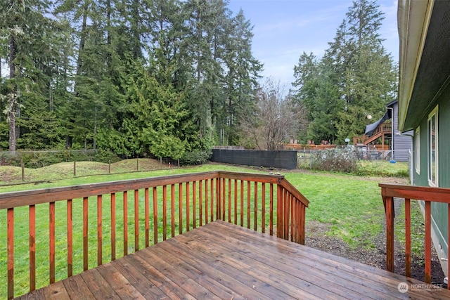 wooden deck featuring a lawn