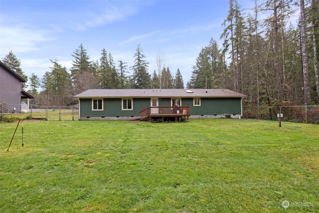 back of house with a deck and a lawn