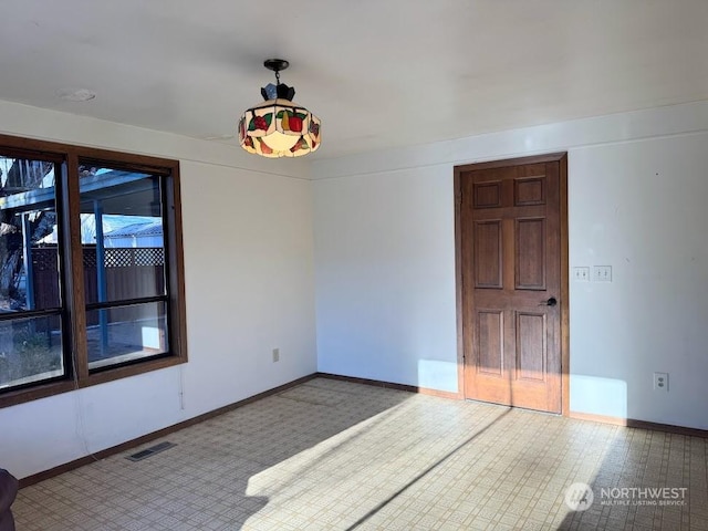 spare room featuring visible vents and baseboards