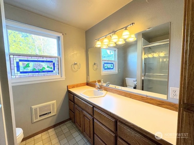 full bathroom with vanity, a shower stall, toilet, and baseboards