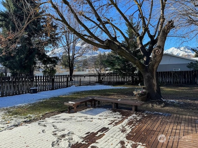 snow covered deck with a fenced front yard