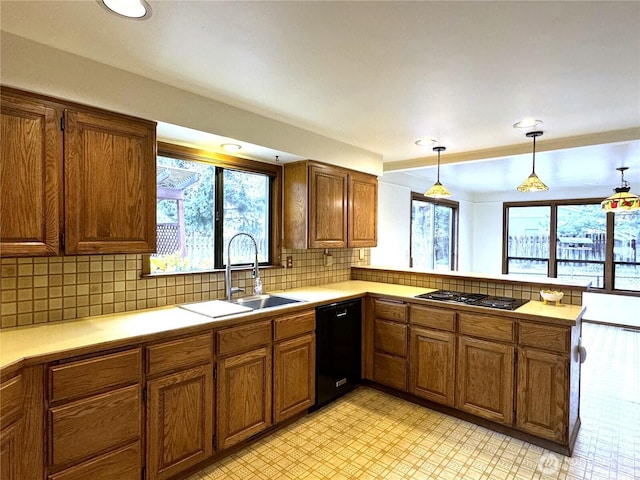 kitchen featuring a sink, black appliances, brown cabinetry, and light countertops