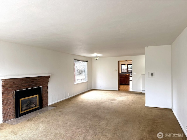 unfurnished living room with a fireplace, baseboards, and carpet floors