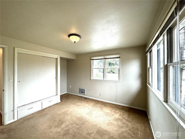 unfurnished bedroom with baseboards, carpet, and a textured ceiling