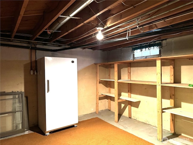 unfinished basement featuring refrigerator