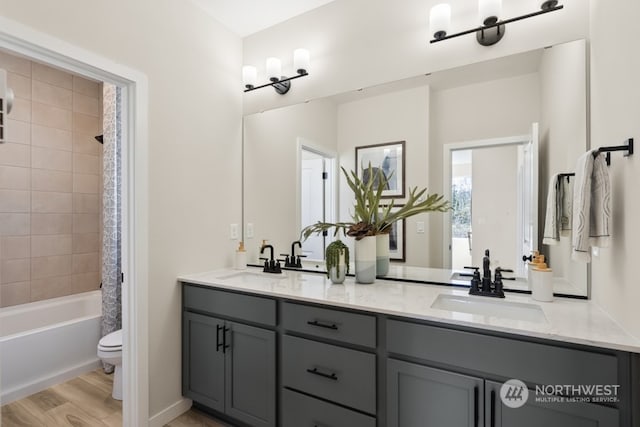 full bathroom with hardwood / wood-style floors, vanity, shower / bath combination with curtain, and toilet