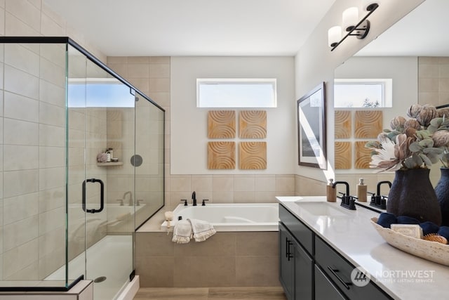 bathroom with vanity and shower with separate bathtub