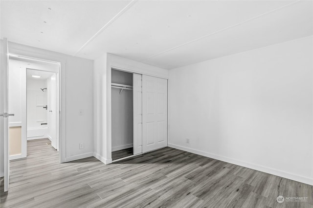 unfurnished bedroom with light hardwood / wood-style floors and a closet