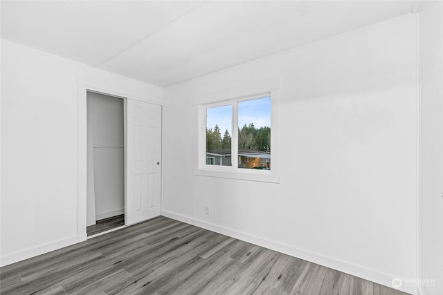 unfurnished bedroom with a closet and dark wood-type flooring